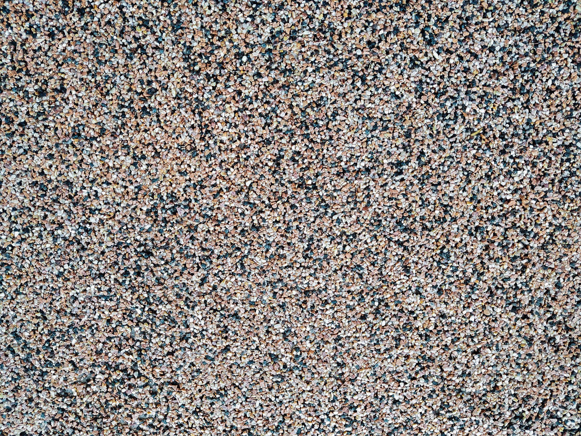 Close up of decorative quartz sand epoxy coated floor or wall coating with grey, black and white coloured particles. Copy space.